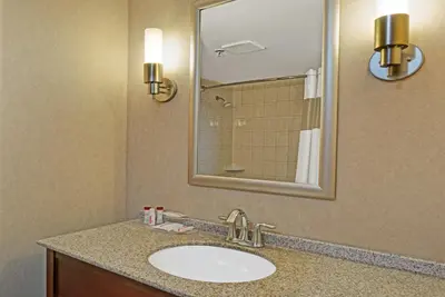 a bathroom with a sink and a mirror at Ramada by Wyndham Niagara Falls/Fallsview in Niagara Falls