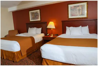 a hotel room with two beds and a lamp at Ramada by Wyndham Niagara Falls/Fallsview in Niagara Falls