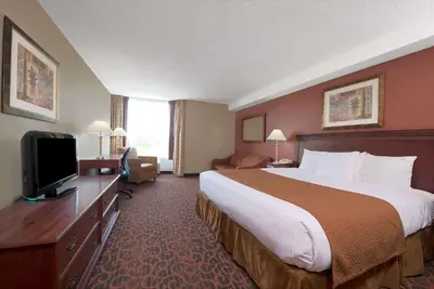a hotel room with a large bed and a television at Ramada by Wyndham Niagara Falls/Fallsview in Niagara Falls