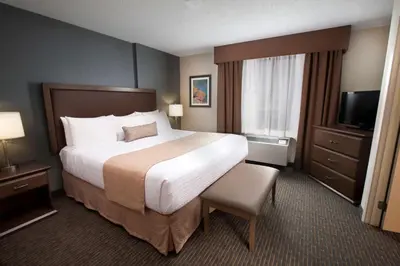 a hotel room with a large bed and a television at Best Western Plus Cairn Croft Hotel in Niagara Falls