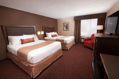 a hotel room with two beds and a television at Best Western Plus Cairn Croft Hotel in Niagara Falls