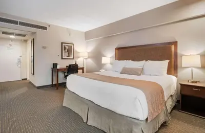 a hotel room with a large bed and a desk at Best Western Plus Cairn Croft Hotel in Niagara Falls
