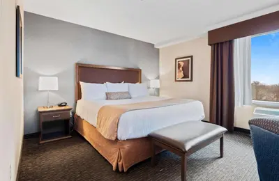 a hotel room with a bed and a window at Best Western Plus Cairn Croft Hotel in Niagara Falls