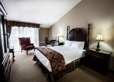 a hotel room with a bed and a chair at Old Stone Inn Boutique Hotel in Niagara Falls