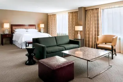 a hotel room with a bed and a couch and a table at Sheraton Centre Toronto Hotel in Toronto