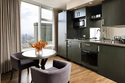 a kitchen with a table and chairs and a window at One King West Hotel and Residence in Toronto