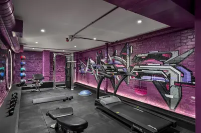 a gym with a purple wall with a painting at Gladstone House in Toronto