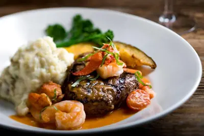 a plate of food with shrimp and vegetables on a table at Niagara Falls Marriott on the Falls in Niagara Falls