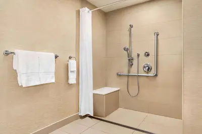 a bathroom with a shower and a toilet at Ramada By Wyndham Niagara Falls near the Falls in Niagara Falls