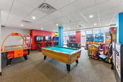 a room with two arcade games and a pool table at Ramada By Wyndham Niagara Falls near the Falls in Niagara Falls