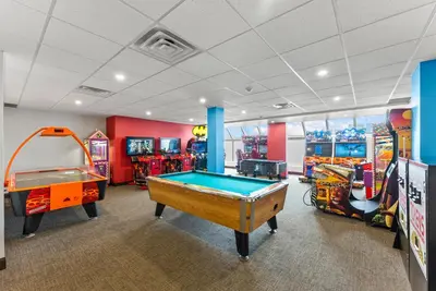 a room with two arcade games and a pool table at Ramada By Wyndham Niagara Falls near the Falls in Niagara Falls