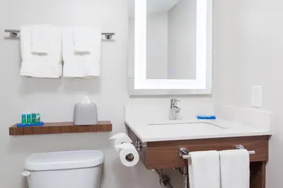 a white bathroom with a sink and a toilet at Holiday Inn Express & Suites Mississauga-Toronto Southwest by IHG in Mississauga
