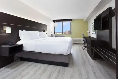 a hotel room with a large bed and a television at Holiday Inn Express & Suites Mississauga-Toronto Southwest by IHG in Mississauga
