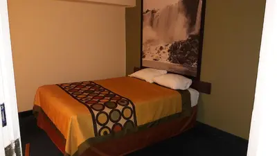 a hotel room with a bed and a picture on the wall at Super 8 by Wyndham Niagara Falls North in Niagara Falls
