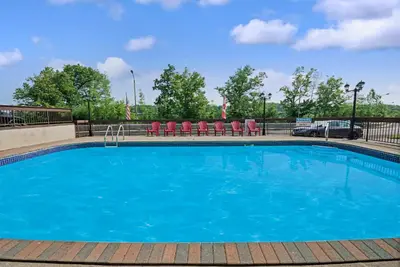 a large blue pool with chairs and a fence at Super 8 by Wyndham Niagara Falls North in Niagara Falls