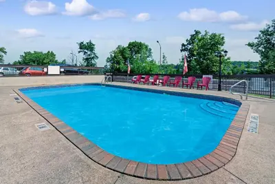 a swimming pool with chairs around it at Super 8 by Wyndham Niagara Falls North in Niagara Falls