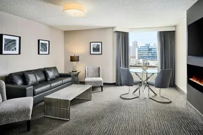 a living room with a couch and a table at Sheraton Hamilton Hotel in Hamilton