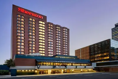 a hotel building with a sign on top of it at Sheraton Hamilton Hotel in Hamilton