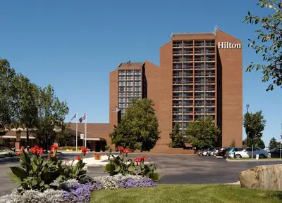 a building with a hotel in front of a parking lot at Hilton Mississauga/Meadowvale in Mississauga