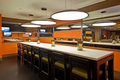 a restaurant with a bar with chairs and lights at Hilton Mississauga/Meadowvale in Mississauga