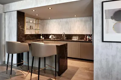 a kitchen with a bar with stools in it at Hilton Mississauga/Meadowvale in Mississauga