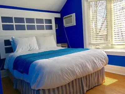 a blue bedroom with a bed with a blue wall at Ellis House Bed & Breakfast in Niagara Falls
