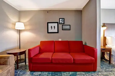 a living room with a red couch in a hotel room at Four Points by Sheraton Toronto Mississauga in Mississauga