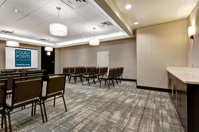 a conference room with chairs and a projection screen at Four Points by Sheraton Toronto Mississauga in Mississauga