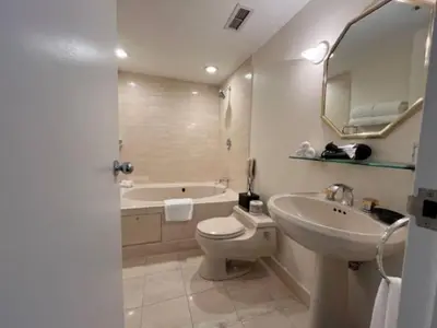 a bathroom with a toilet and a sink and a tub at Cambridge Suites Toronto in Toronto