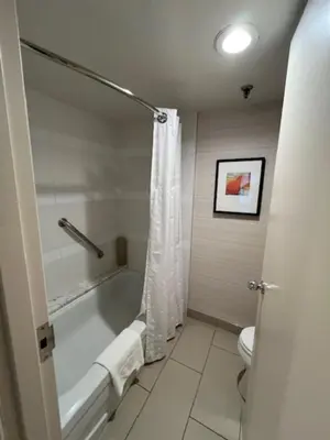 a bathroom with a bath tub and a toilet at Cambridge Suites Toronto in Toronto