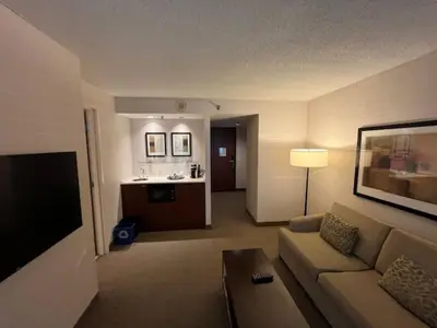 a living room with a couch and a kitchen at Cambridge Suites Toronto in Toronto