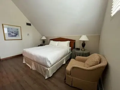 a hotel room with a bed and a chair at Cambridge Suites Toronto in Toronto
