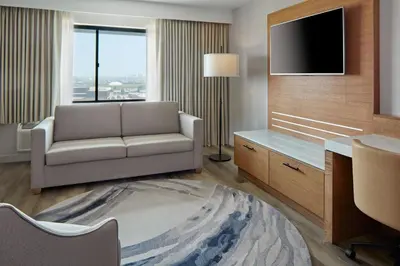 a living room with a couch and a tv at Delta Hotels by Marriott Toronto Markham in Markham