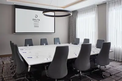a conference room with a table and chairs and a screen at Delta Hotels by Marriott Toronto Markham in Markham