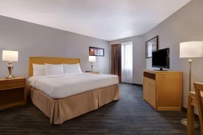 a hotel room with a bed and a flat screen tv at Days Inn by Wyndham Niagara Falls Near The Falls in Niagara Falls