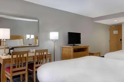 a hotel room with a bed and a desk and a television at Days Inn by Wyndham Niagara Falls Near The Falls in Niagara Falls