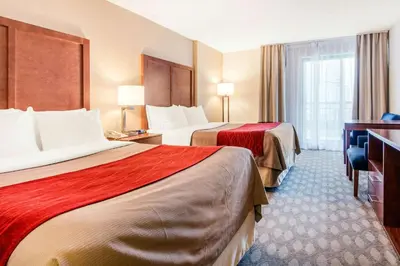 a hotel room with two beds and a desk at Comfort Inn Fallsview in Niagara Falls