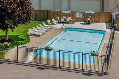 a large swimming pool with chairs and umbrellas at Travelodge by Wyndham Niagara Falls At the Falls in Niagara Falls