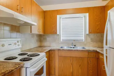 a kitchen with a white stove and a sink at Travelodge by Wyndham Niagara Falls At the Falls in Niagara Falls