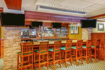 a bar in a restaurant with chairs and televisions at Travelodge by Wyndham Niagara Falls At the Falls in Niagara Falls