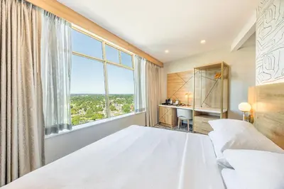 a bedroom with a white bed and a large window at Tower Hotel at Fallsview in Niagara Falls