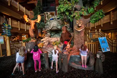 a group of children standing in front of a waterfall at Great Wolf Lodge Waterpark Resort in Niagara Falls
