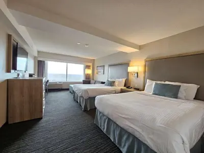 a hotel room with two beds and a television at Vittoria Hotel & Suites in Niagara Falls