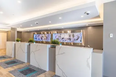 a lobby with a reception counter with paintings on the wall at Vittoria Hotel & Suites in Niagara Falls