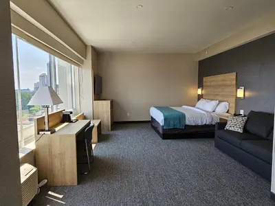 a hotel room with a bed and a couch at Vittoria Hotel & Suites in Niagara Falls