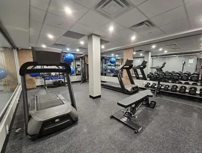 a gym with several treadmills and machines in it at Vittoria Hotel & Suites in Niagara Falls