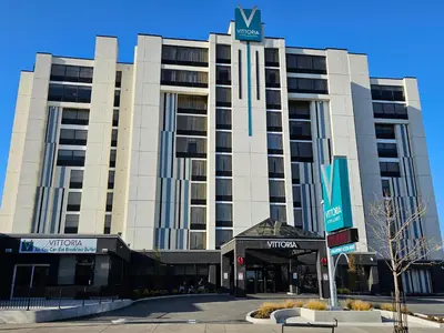 a large building with a sign on top of it at Vittoria Hotel & Suites in Niagara Falls