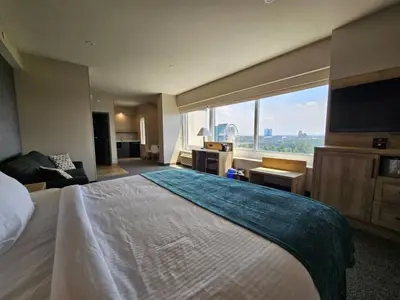a hotel room with a large bed and a large window at Vittoria Hotel & Suites in Niagara Falls
