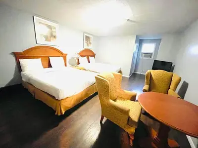 a hotel room with a bed and a table and chairs at A1 Inn Niagara Falls in Niagara Falls
