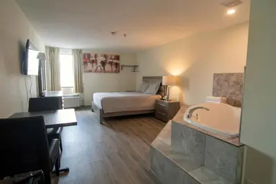 a hotel room with a bed and a bath tub at Diplomat Inn in Niagara Falls